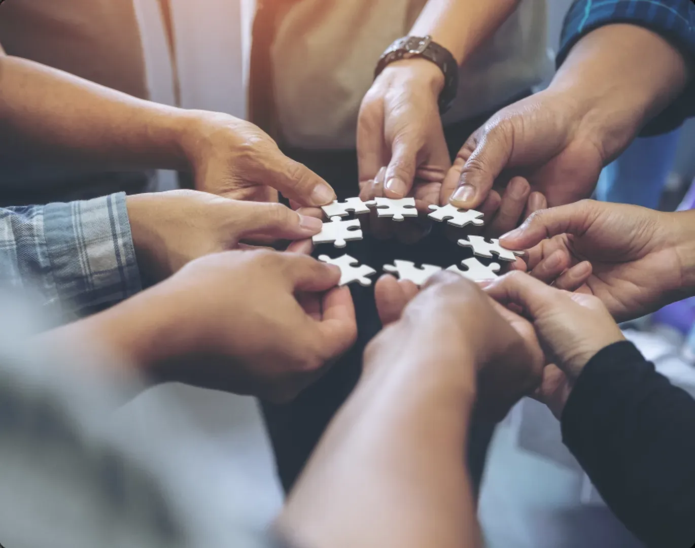 Team members joining puzzle pieces together