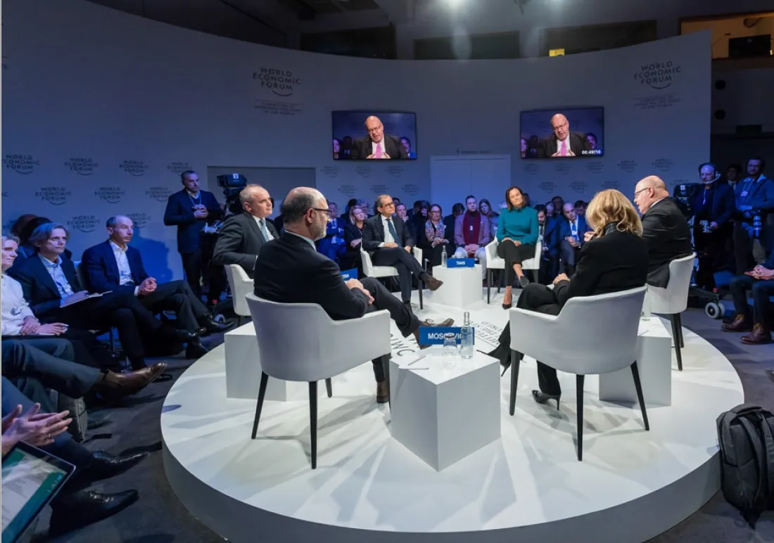 A panel discussion on a round stage at the World Economic Forum