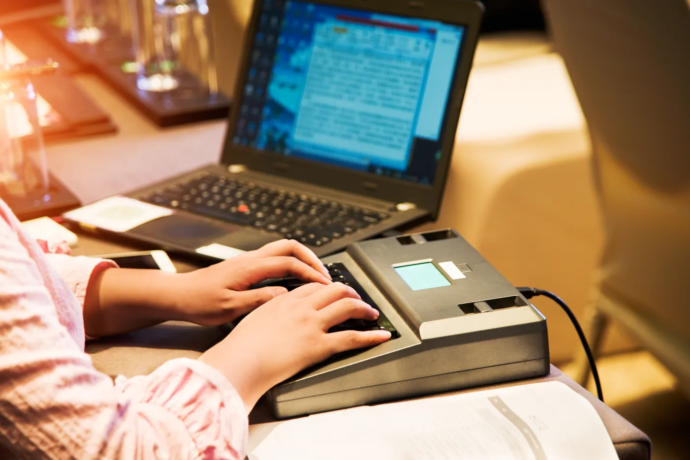 A CART captioner writing on a stenotype machine