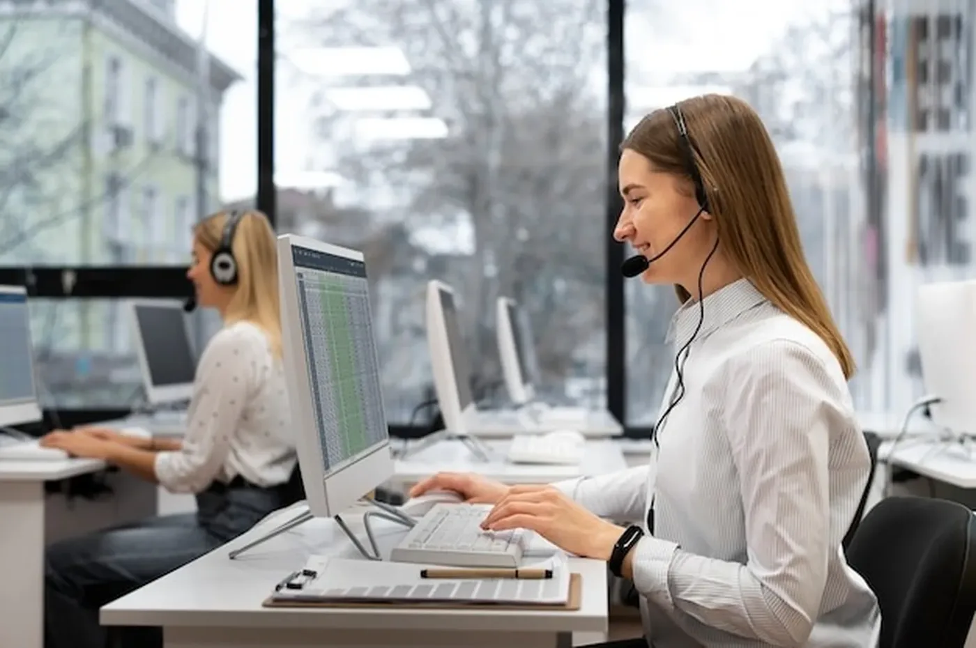Admissions staff with headsets assisting callers at their desks