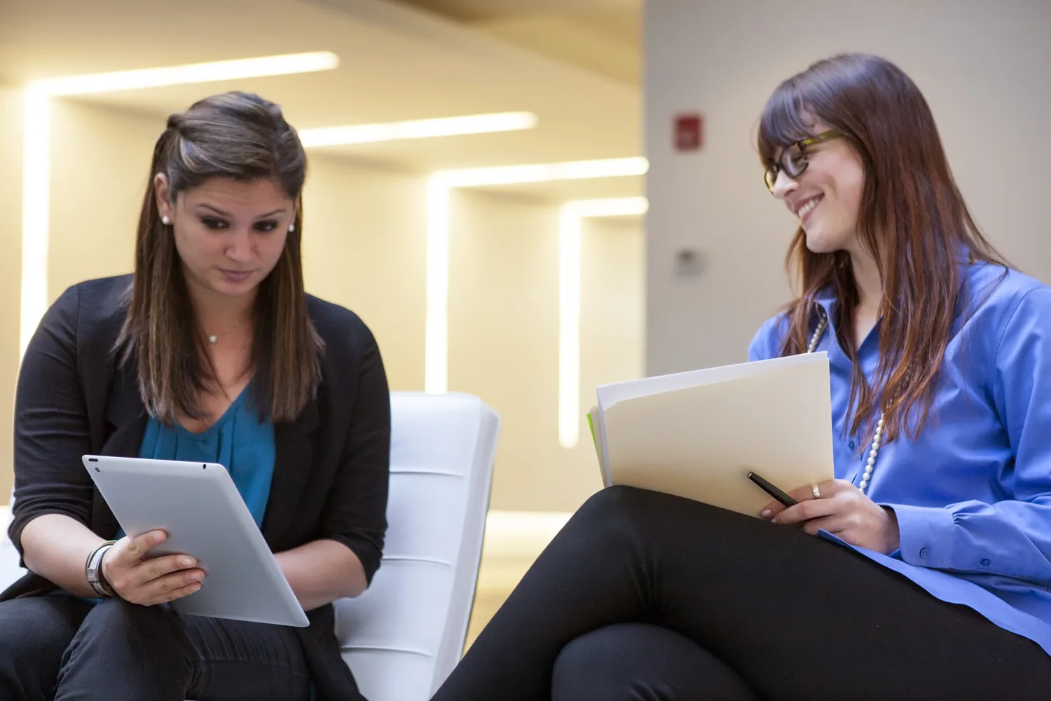 Two colleagues complete a training module together on a tablet