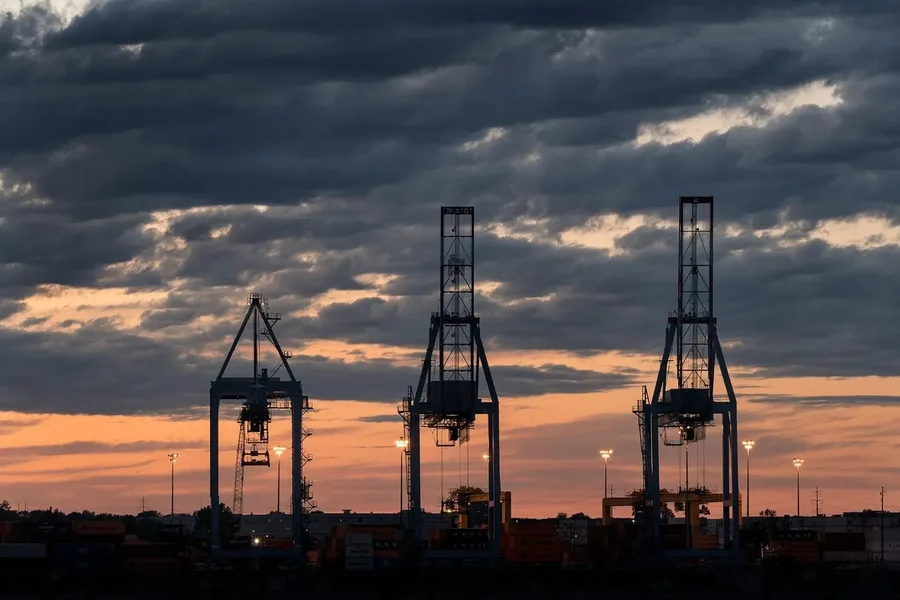 Container cranes at an industrial port at sunset