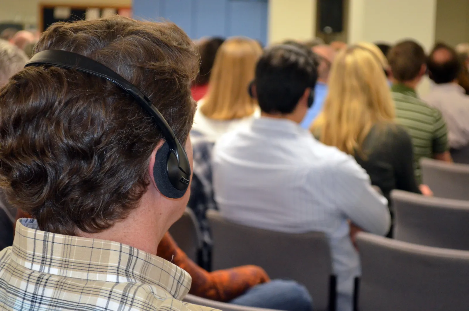 An audience listening through interpreting headsets