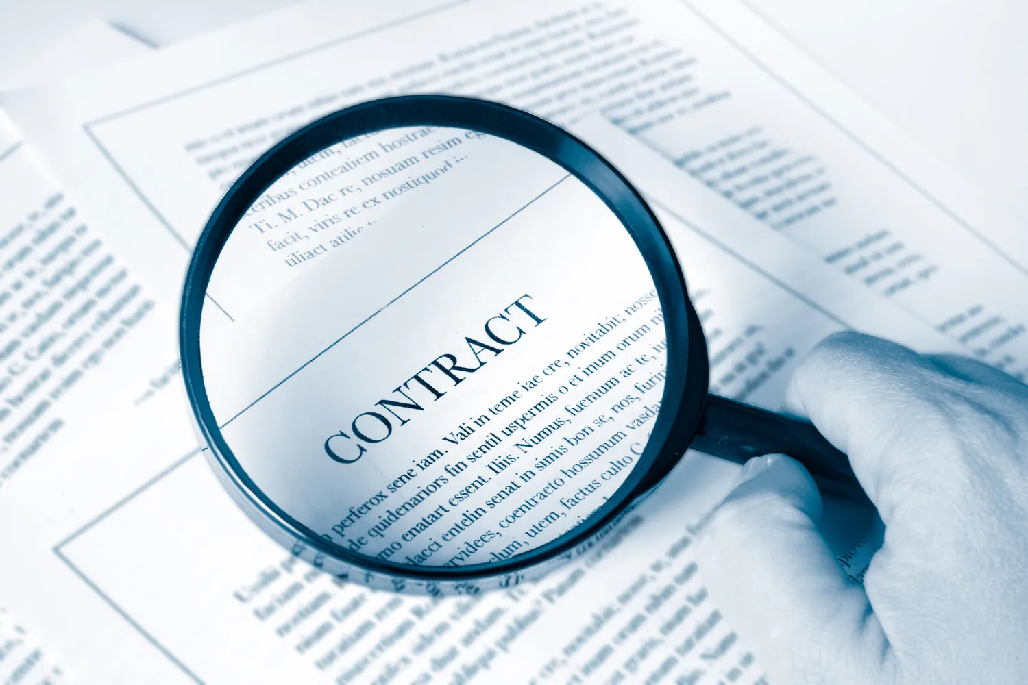 A magnifying glass held over a contract during a document review