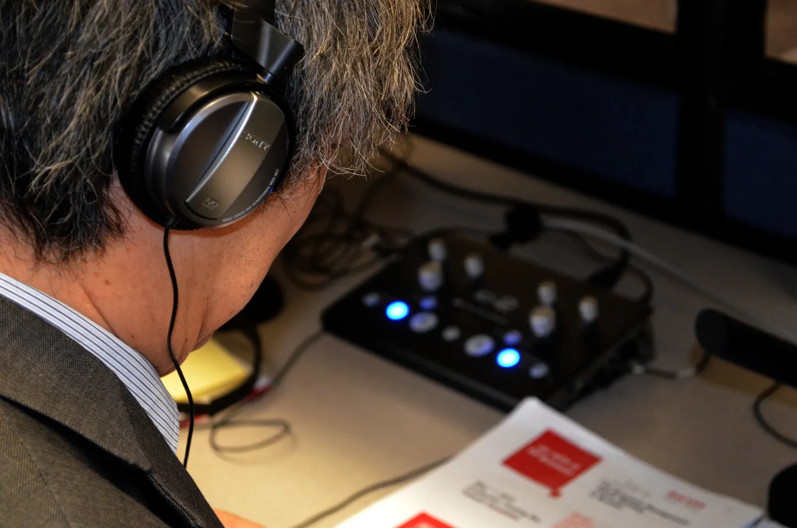 A simultaneous interpreter wearing headphones works at an interpreting console