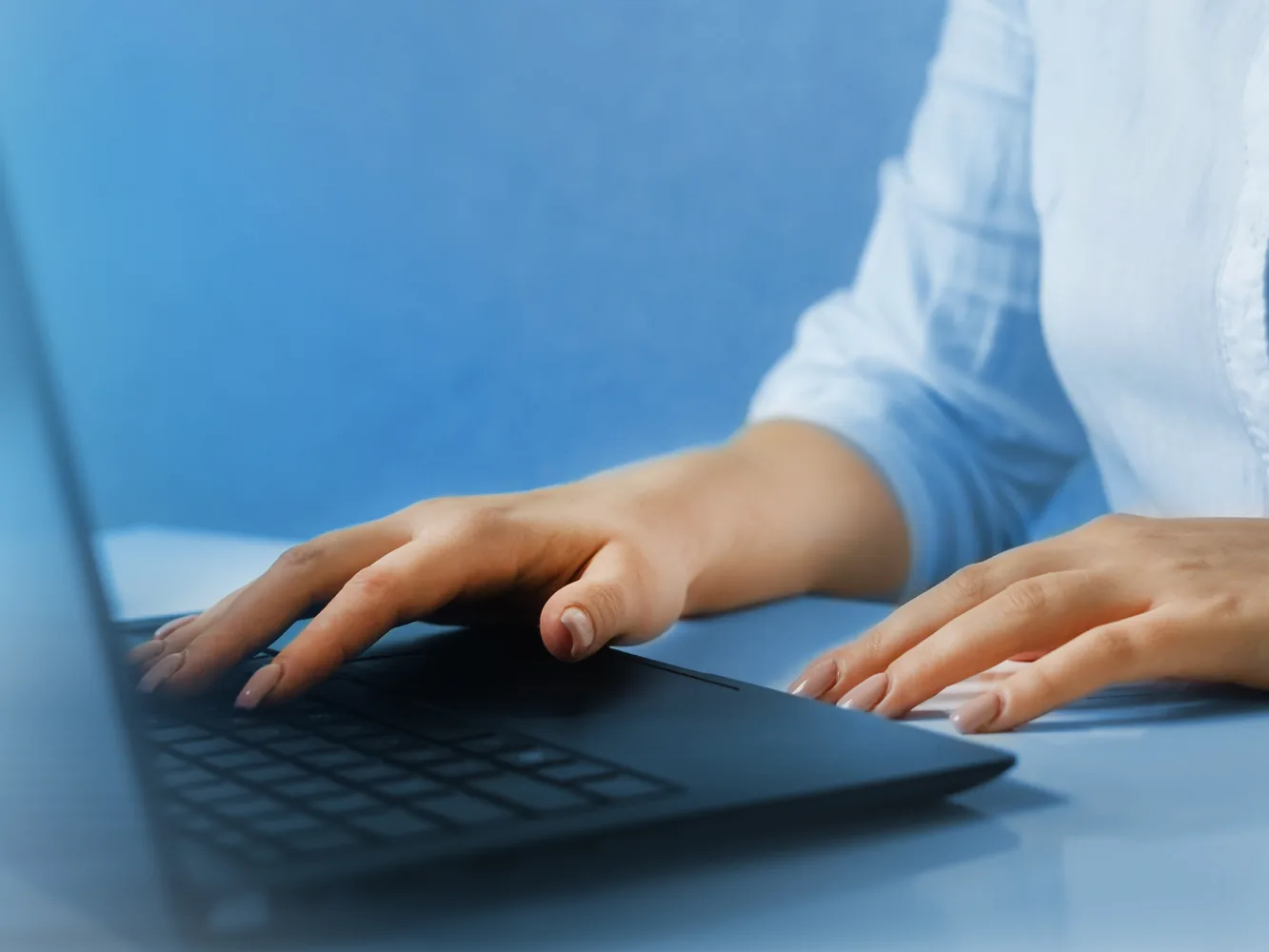 A linguist types a transcript on a laptop